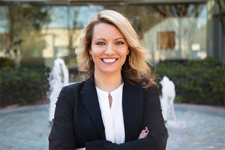 Ashley Stone in a black blazer, smiling outdoors